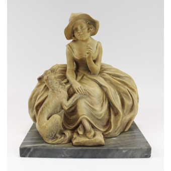 Een terracotta sculptuur van een dame met hond